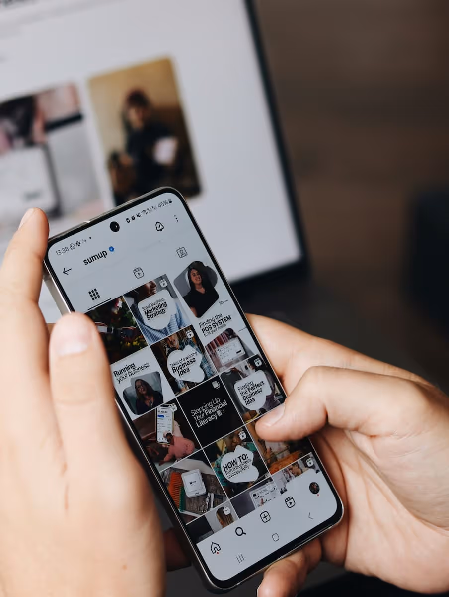 Une personne tenant un téléphone intelligent affichant le profil Instagram de SumUp avec des publications sur la stratégie marketing et les idées d'affaires.